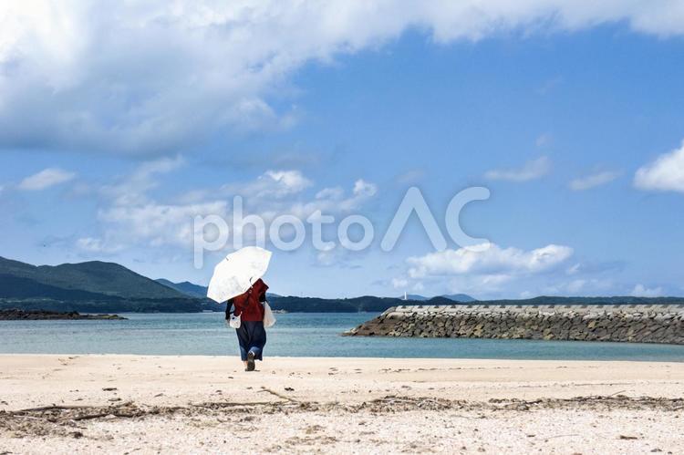 ＜素材＞真夏の浜辺を日傘で散策する女性 女性,人物,風景の写真素材