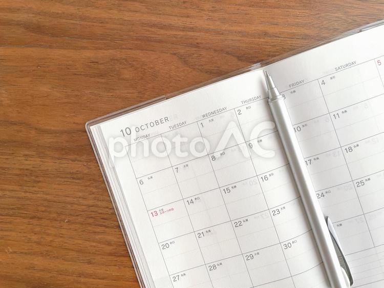 木の机に置かれた10月のカレンダーとペン スケジュール帳,手帳,10月の写真素材