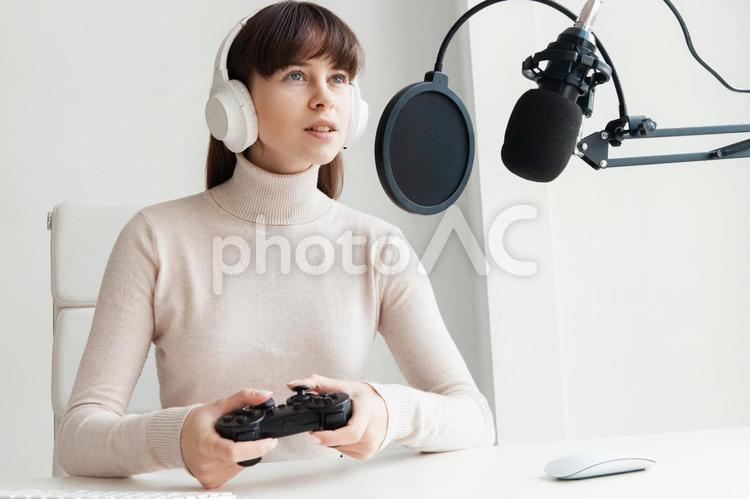 ヘッドフォンをしてコントローラーを持ってゲームする女性 女性,人物,若者の写真素材