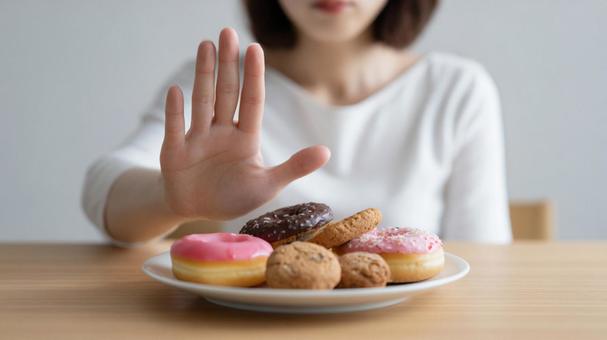 糖質制限 ドーナツとクッキーを拒む女性 糖質制限 ドーナツとクッキーを拒む女性の写真