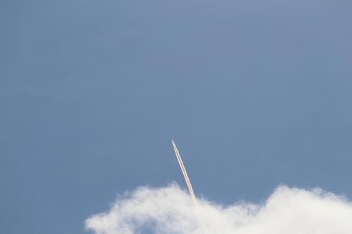 青空と白い雲からのびる飛行機雲のある空 青空と白い雲からのびる飛行機雲のある空の写真