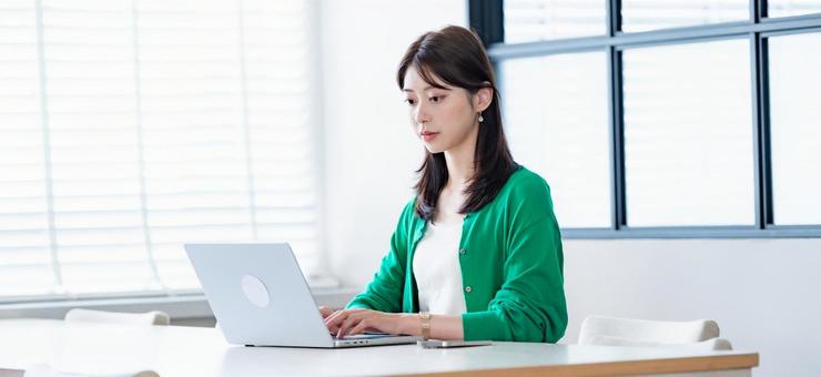 明るい室内で仕事をする女性 明るい室内で仕事をする女性 女性,ノートパソコン,パソコンの写真素材