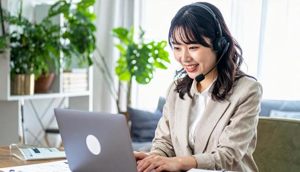 笑顔でリモートワークをするビジネス女性 笑顔でリモートワークをするビジネス女性の写真