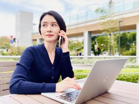 A nomad worker woman who calls on a smartphone, computer, mobile phone, smartphone, JPG