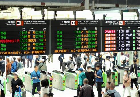 多くの人で混雑する駅の改札と電光掲示板 駅,改札,改札口の写真素材