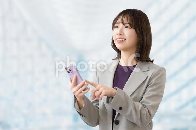 スマホを使う笑顔の女性・ビジネスウーマン 女性,ビジネス,笑顔の写真素材