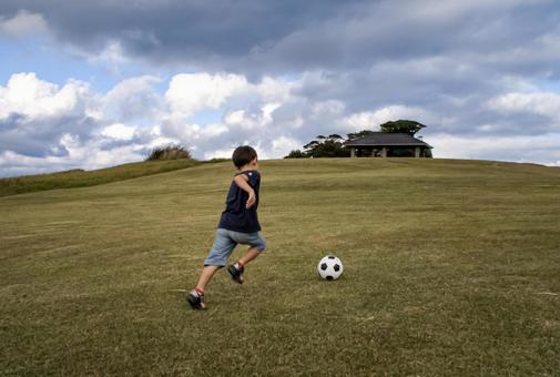 ＜素材＞山頂で元気にサッカーをする男の子 子供,サッカー,運動の写真素材