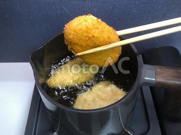 鋳物の鉄鍋で揚げた冷凍コロッケ 鋳鉄,コロッケ,冷凍食品の写真素材