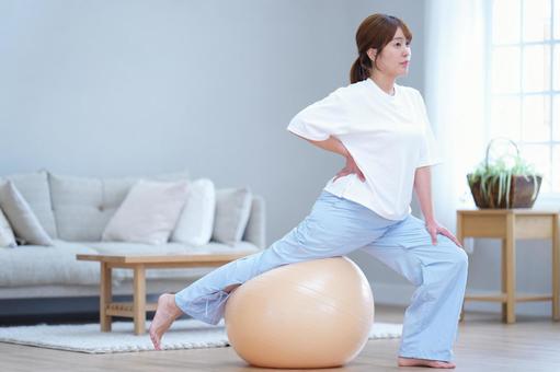 ボールに片足をのせストレッチする女性 女性,バランスボール,足の写真素材