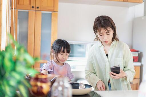 お母さんと一緒に料理をする小さな女の子 レシピ,お手伝い,母の写真素材