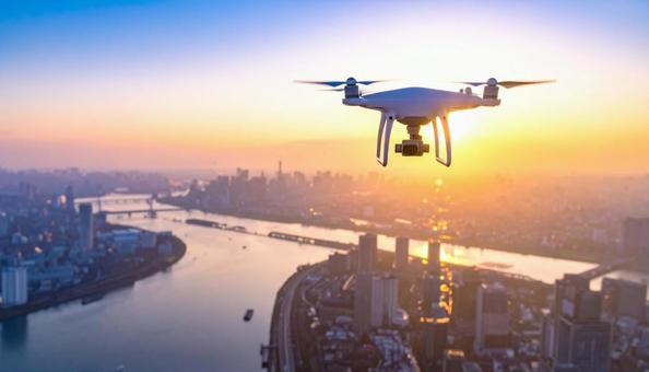 都市上空を飛行するドローン 都市上空を飛行するドローンの写真