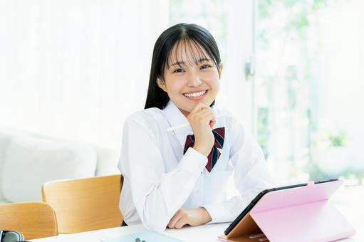 タブレットで勉強する女子高生 タブレットで勉強する女子高生 高校生,笑顔,タブレットの写真素材