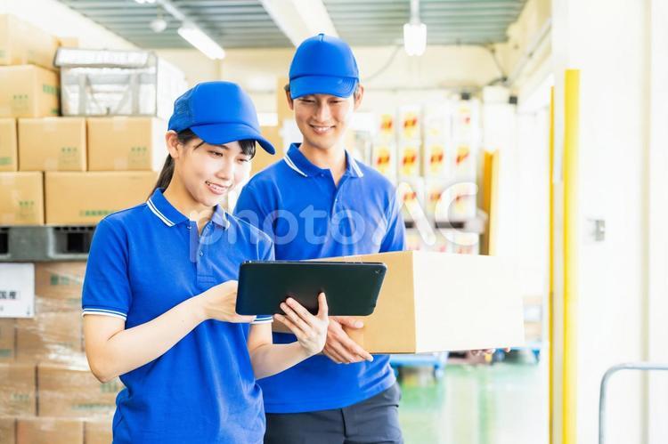 荷物を管理する若いスタッフ 倉庫,工場,笑顔の写真素材
