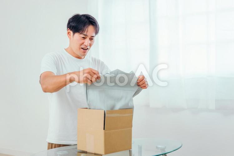 届いた商品に納得がいかない男性（不良品・返品） 不良品,返品,クーリングオフの写真素材