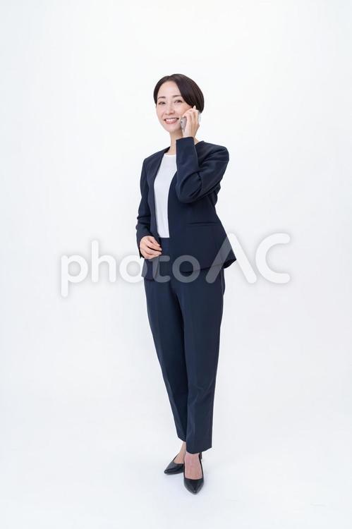 スマホを持ちカメラ目線の女性 会社員,営業,キャリアの写真素材