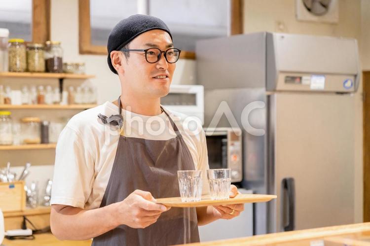 カフェのキッチンで水を持つ男性スタッフ カフェ,店員,スタッフの写真素材