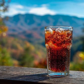 絶景を眺めるコーラのグラスの写真