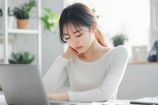 デスクワークで眠そうな女性の表情 デスクワークで眠そうな女性の表情の写真