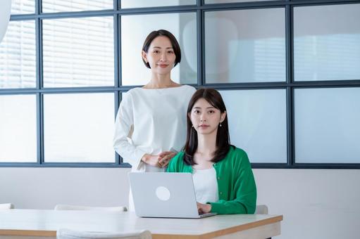 窓のある部屋でパソコンを見る女性二人 窓のある部屋でパソコンを見る女性二人 会議,教える,女性の写真素材