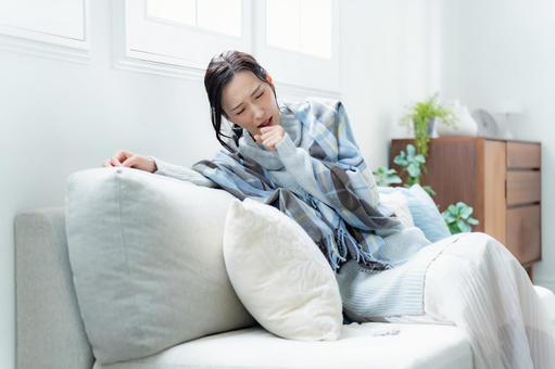 ソファで咳をする女性 疲労,咳,体調管理の写真素材