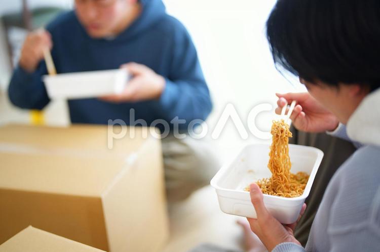 引っ越しの合間にカップ焼きそばを食べる2人の男性 引っ越し,一人暮らし,男性の写真素材