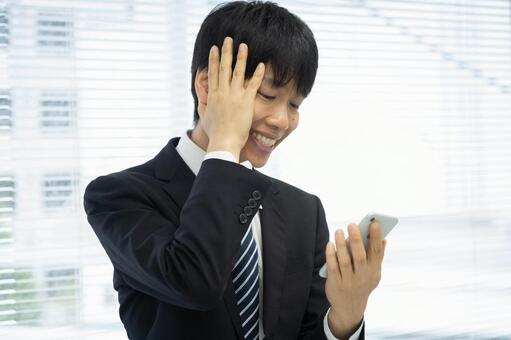 スマホ見て落ち込むビジネスマン男性 ビジネスマン,スマートフォン,男性の写真素材