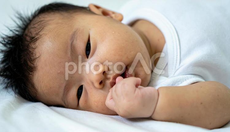 指しゃぶりするカメラ目線の赤ちゃん 赤ちゃん,ベビー,指しゃぶりの写真素材