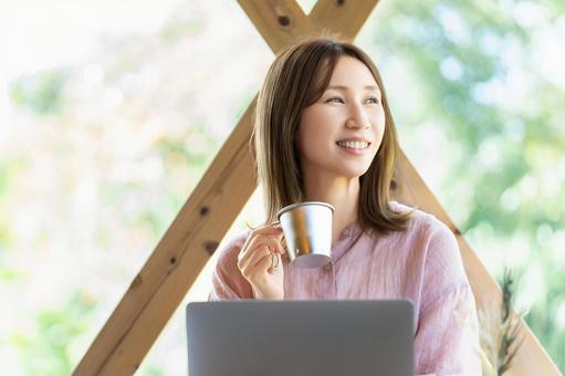 カフェでパソコンを使って仕事をする女性 女性,パソコン,ノートパソコンの写真素材