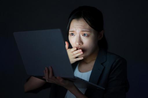 女性が画面を見て驚く 女性,ノートパソコン,持つの写真素材