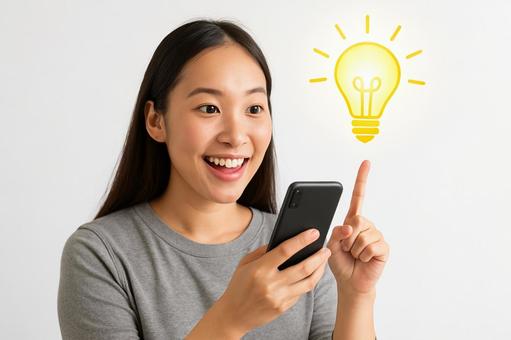 スマホでひらめく女性の笑顔 スマホでひらめく女性の笑顔の写真