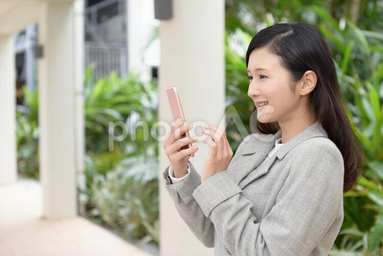 スマートフォンを持つ笑顔の女性 女性,スマートフォン,女の写真素材