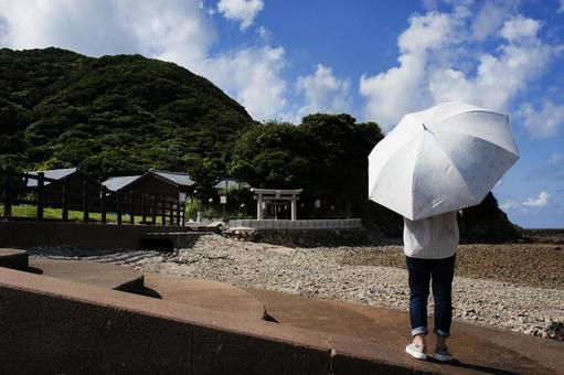 <素材>夏の海を散歩する日傘の女性 <素材>夏の海を散歩する日傘の女性の写真