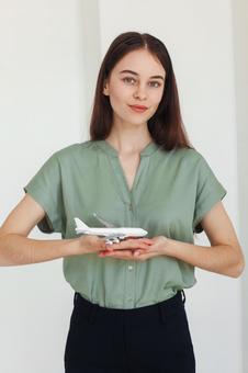 両手で飛行機の模型を持つ女性スタッフ 事務職,接客業,アドバイザーの写真素材