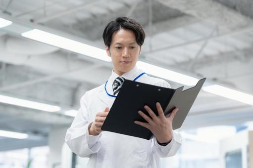 実験をする白衣の若い男性研究者 実験をする白衣の若い男性研究者 研究,実験,サイエンスの写真素材