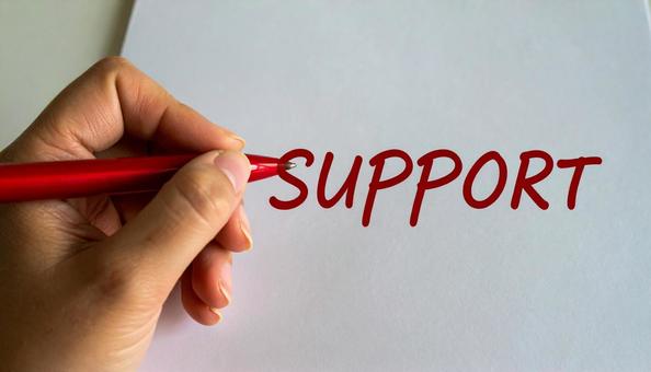文字「Support」と赤ペンで書く手元 文字「Support」と赤ペンで書く手元の写真