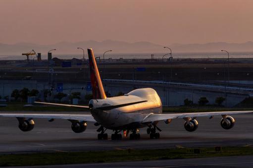 夕陽でオレンジに輝く大型旅客機 夕陽でオレンジに輝く大型旅客機 飛行機,航空機,旅客機の写真素材