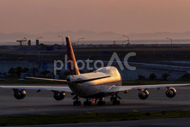 夕陽でオレンジに輝く大型旅客機 飛行機,航空機,旅客機の写真素材