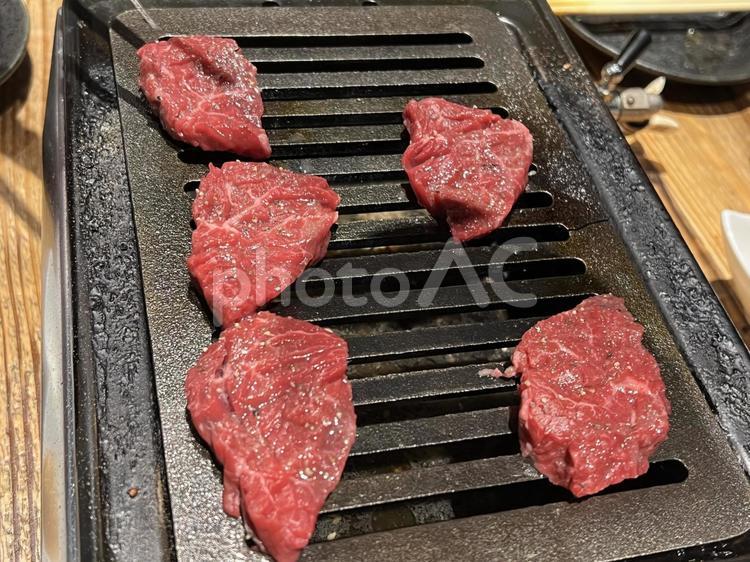 焼き網の上で焼かれる美味しそうな牛肉 生肉,焼き網,ハラミの写真素材