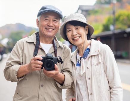カメラを持って旅する仲良しシニア夫婦の写真