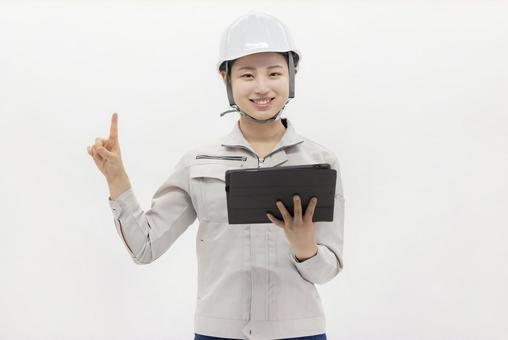 タブレットを持つ作業着の女性 タブレットを持つ作業着の女性 女性,ビジネスウーマン,タブレットの写真素材
