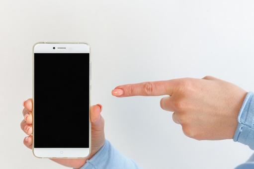 スマートフォンの画面を指差す女性 スマートフォン,黒画面,女性の写真素材