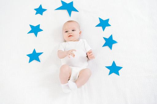 青い星に囲まれた仰向けの赤ちゃんｍa 赤ちゃん,かわいい,仰向けの写真素材
