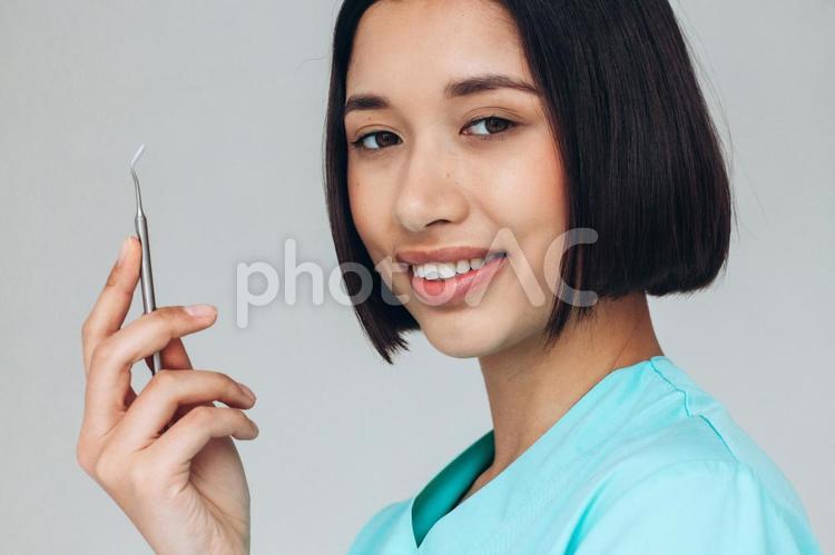 医療器具を持ってカメラ目線で振り向く女性 女性,歯科医,振り向くの写真素材