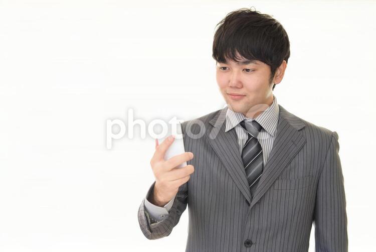 スマートフォンを持つビジネスマン 男性,ビジネスマン,男の写真素材