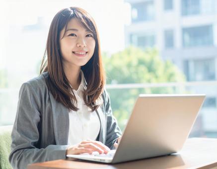 ノートパソコンを操作する若い女性 ノートパソコンを操作する若い女性の写真