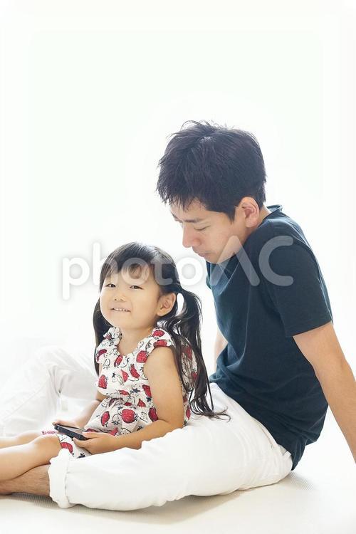 一緒にスマホを見る親子 父と娘,休日,仲良しの写真素材