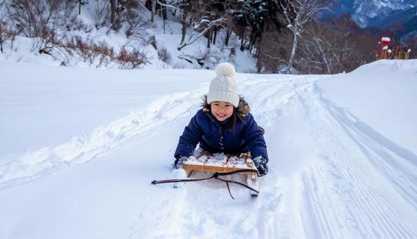 雪の中、そりで遊ぶ日本人の女の子 雪の中、そりで遊ぶ日本人の女の子の写真