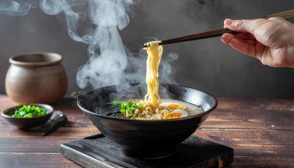 湯気が立つ豚骨ラーメンをリフトアップ 湯気が立つ豚骨ラーメンをリフトアップの写真