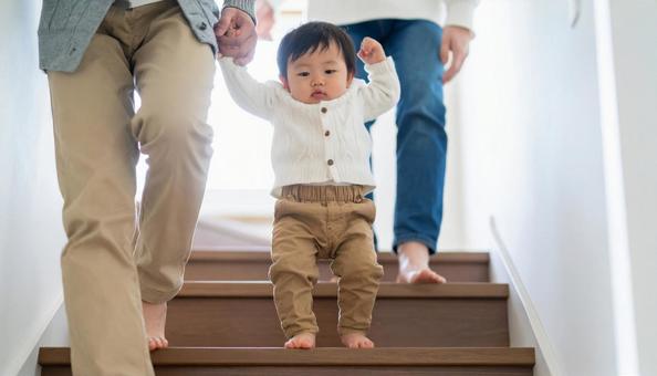 階段を下りるのが楽しい子供と見守る両親 階段を下りるのが楽しい子供と見守る両親の写真