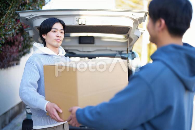 車から引っ越しの段ボールを運び出す2人の男性 引っ越し,一人暮らし,男性の写真素材